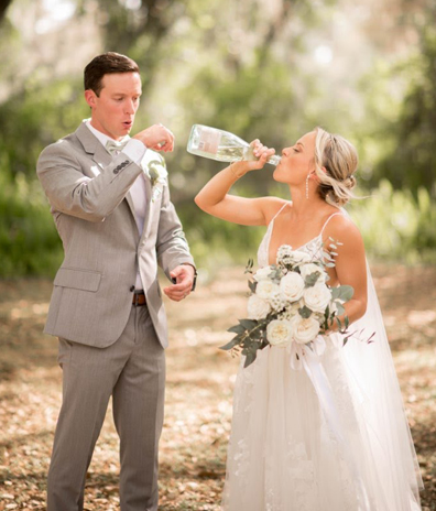 bride in white dress drinking champagne groom in gray suit beautiful bridal spray tan party in Merritt Island Florida